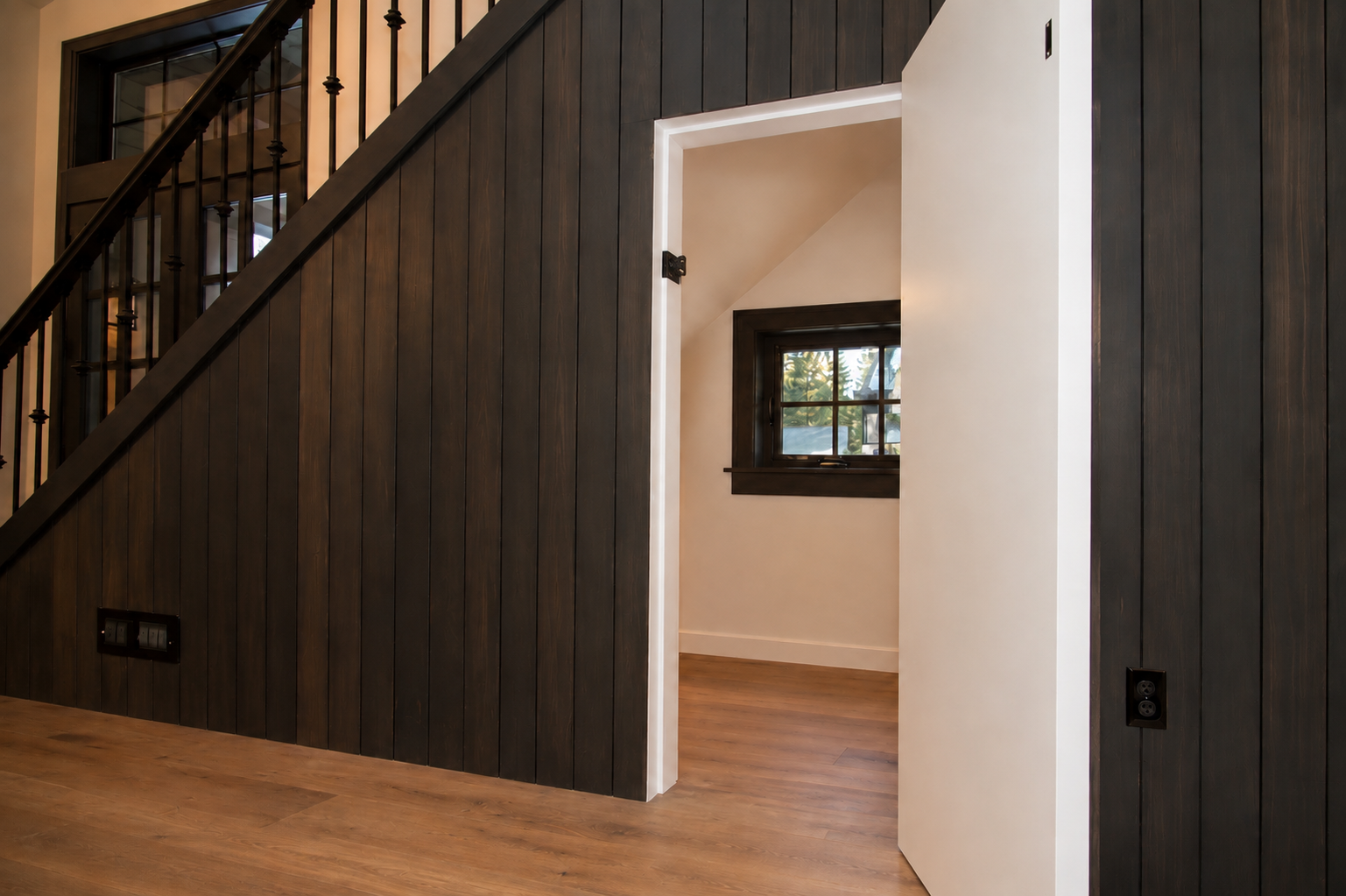 Dark stained wood wall paneling and built-in millwork with staircase detail