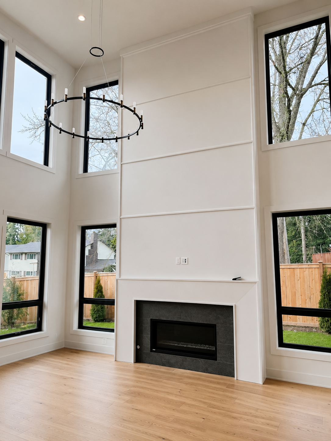 Two-story feature wall with custom trim, panel moulding and modern fireplace surround